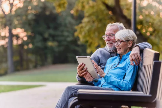 Couple on a bench with tablet